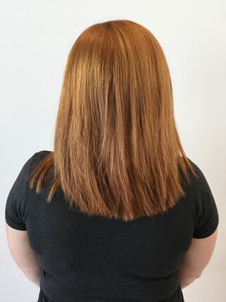 Photo avant : vue arrière d'une femme aux cheveux châtain clair inégaux de longueur moyenne avec des longues racines avant la coloration.