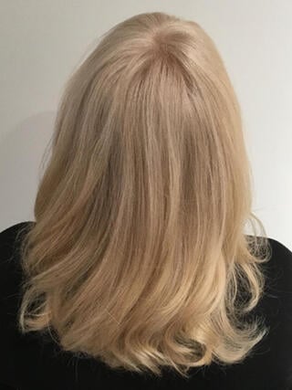 Photo d'après : vue arrière d'une femme aux cheveux mi-longs blonds, après coloration.