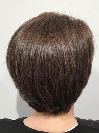 Photo après : vue arrière d'une femme aux cheveux bruns courts sans cheveux blancs après coloration.