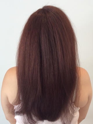 Photo après : vue arrière d’une femme aux longs cheveux roux en bonne santé après coloration.