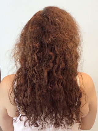 Photo avant : vue arrière d’une femme aux longs cheveux roux abîmés avant la coloration.