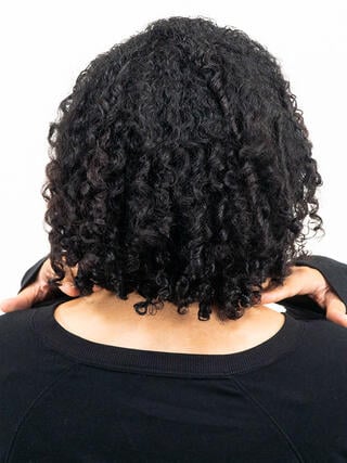 Après la photo : vue arrière d’une femme aux cheveux noirs courts avec une couleur uniforme partout.